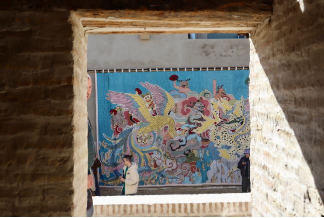 هنرمند خادم علی با همکاری صنعتگران ازبکی، سنجر نظراف و سعید کامالوف، برای خلق یک تابلوی گوبلن حماسی که افسانه&zwnj;هایی از ریشه&zwnj;های هزارگی او در افغانستان را با استفاده از یک روش ازبکی روایت می&zwnj;کند، همکاری کرد. این اثر در کاروانسرای بخارا آویزان شد که در سده&zwnj;های هجدهم و نوزدهم خدمت&zwnj;گزار تاجران جاده ابریشم بود. (الکساندر تامپسون/یورایشینت)